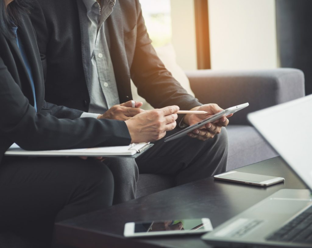 Empresários lendo informações em um tablet - Contratos de mútuo conversível?